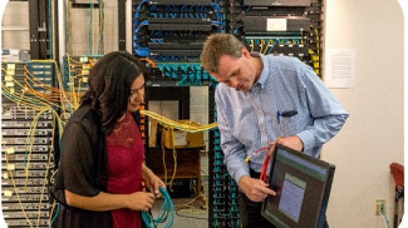 professor and student examining computer wires