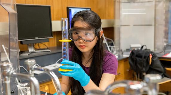 girl in science lab doing an experiment