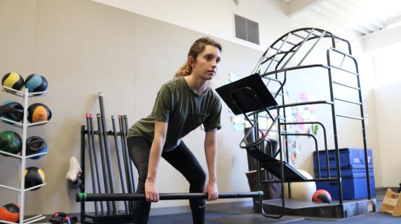 person doing a squat with a weighted bar