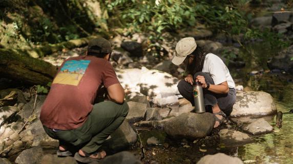 two people observing a creek