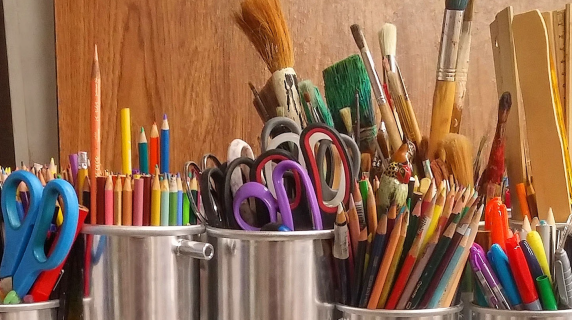 artists work table with brushes, pencils and other tools ready to go for project