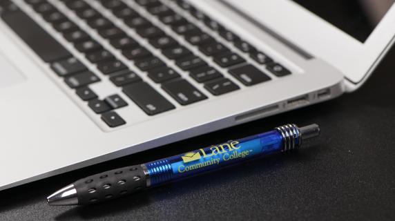 close up of laptop with an lcc-branded pen next to it
