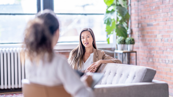 a patient and therapist talking in a sunny, inviting room