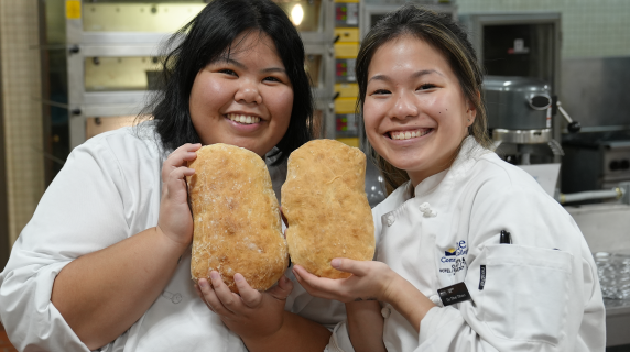 baking and culinary students smiling and showing off bread they've baked