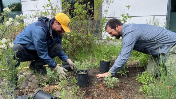 Sustainability Coordinator Luis Maggiori and Earth Sciences Instructor Rick Glover smiling and planting trees on campus