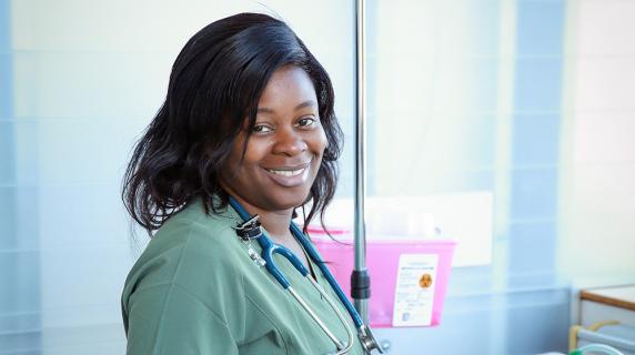 a scholarship winner, a young Black woman in nursing scrubs