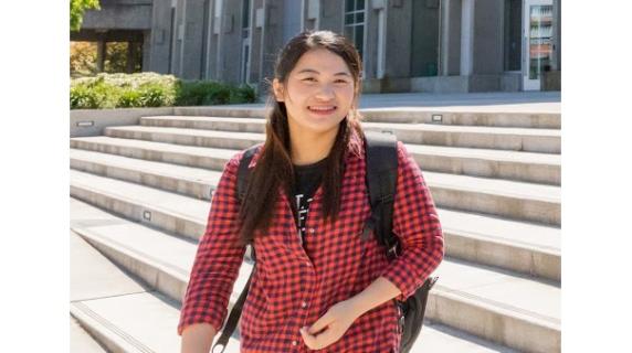 international-student outdoors in steps leading the center building
