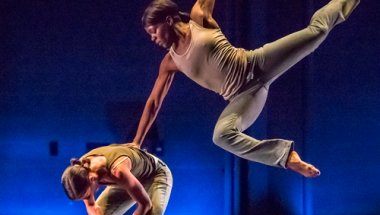 two college dancers preforming on stage 