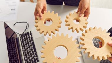 people fitting gears together at a desk