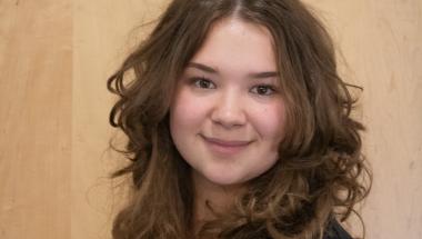 Sophie Gibson, a young woman with curly brown hair and a big smile
