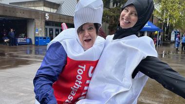 two LCC dental faculty smile and pose in goofy toothpaste costumes at the LCC open house