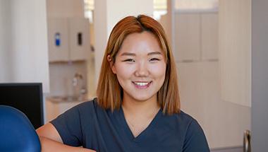 Headshot of Dabin, in a dental hygiene uniform, at a dental clinic 