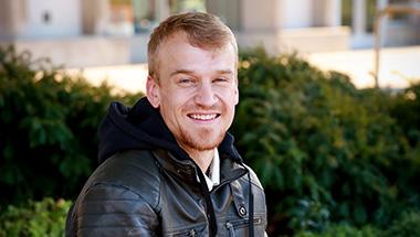 Headshot of Sean, outside in front of a bush