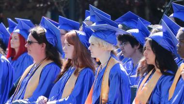 Phi Theta Kappa honor students in blue caps and gown at a community college graduation ceremony