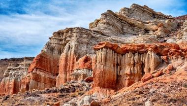 Mojave Desert rock formation with brillant red stripes against a blue sky (photo by jdblack)