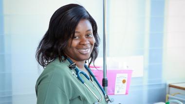 a scholarship winner, a young Black woman in nursing scrubs