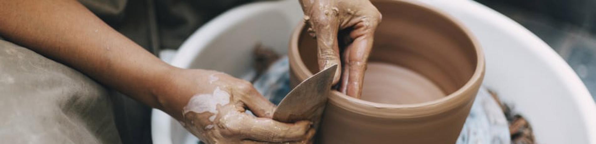 a person making pottery on a wheel