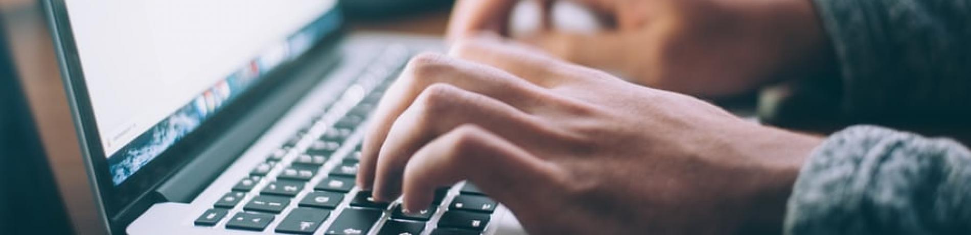 closeup of someone typing on a laptop 