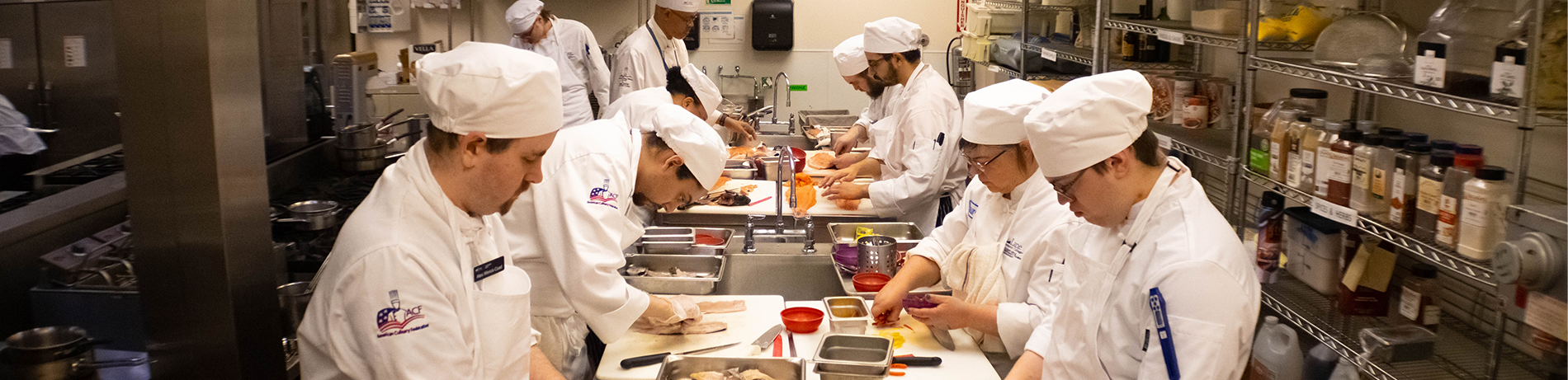 Culinary students working around a prep table