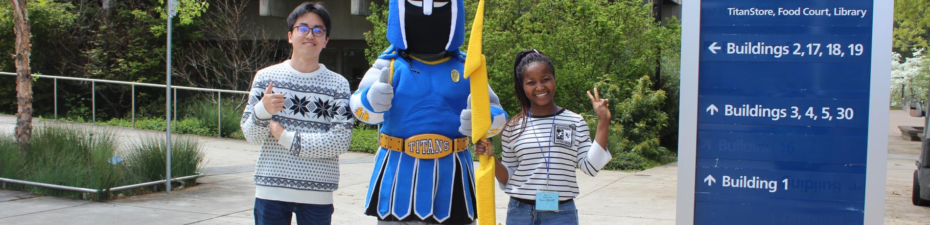 ty the titan with students in front of a sign