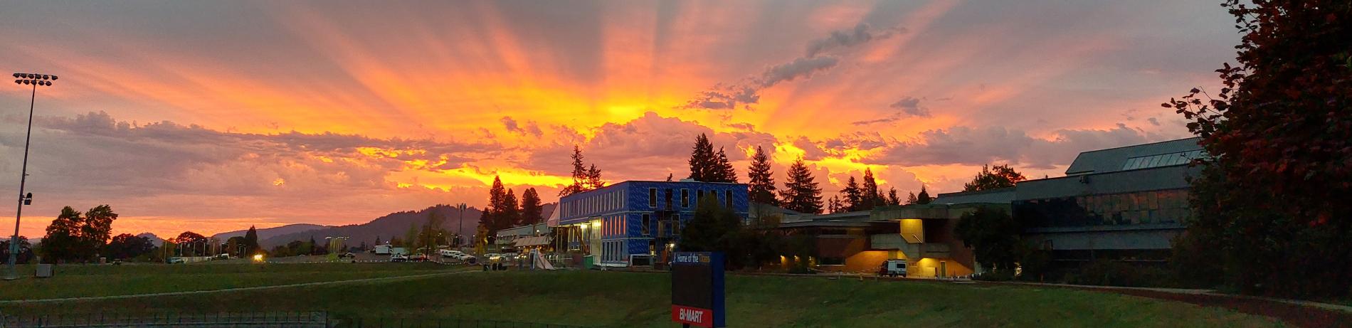 a building under construction with a sunset in background and the LCC track in foreground