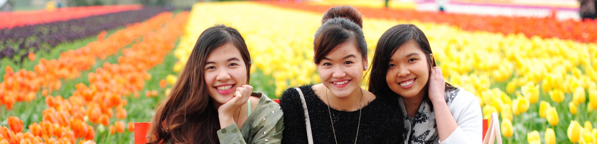 three international students smiling in a tulip field