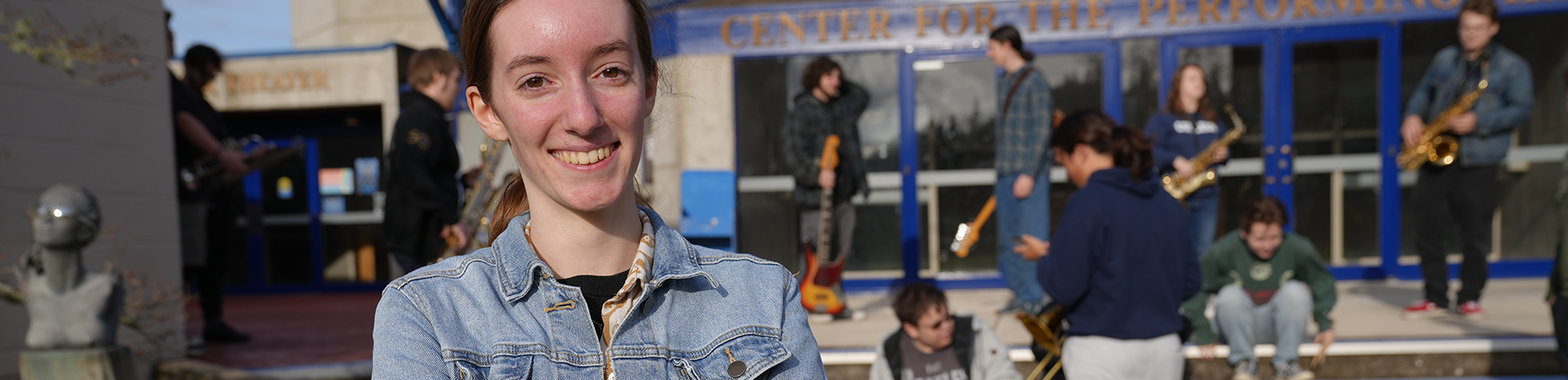 a smiling band student with friends in the background 