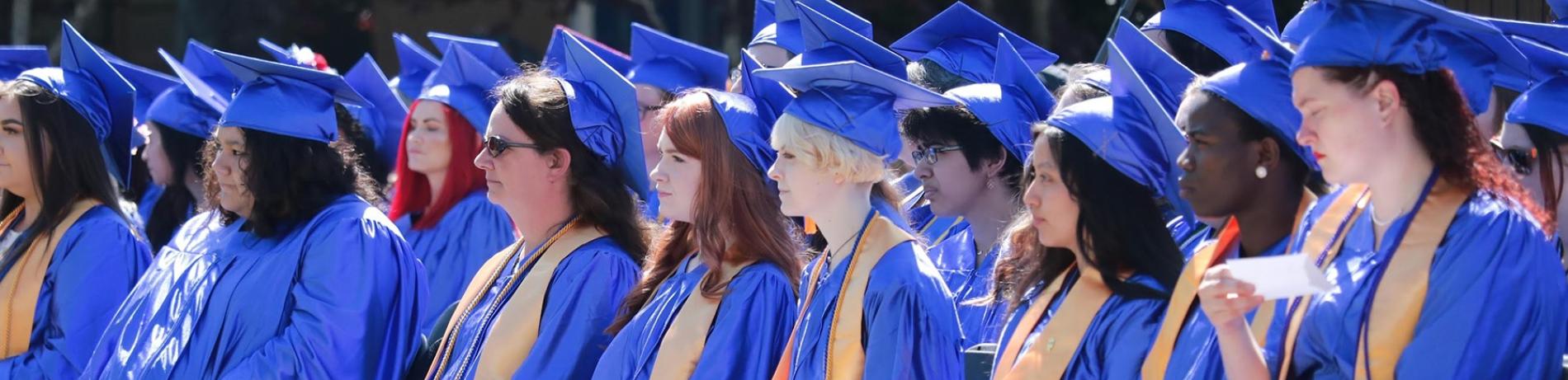 Phi Theta Kappa honor students in blue caps and gown at a community college graduation ceremony