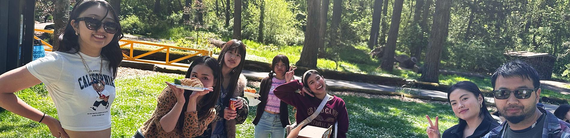 international students smiling and posing during a picnic at a forest park in Eugene