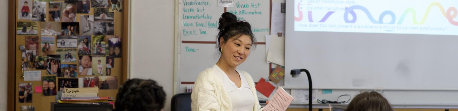 a high school teacher in front of a projector