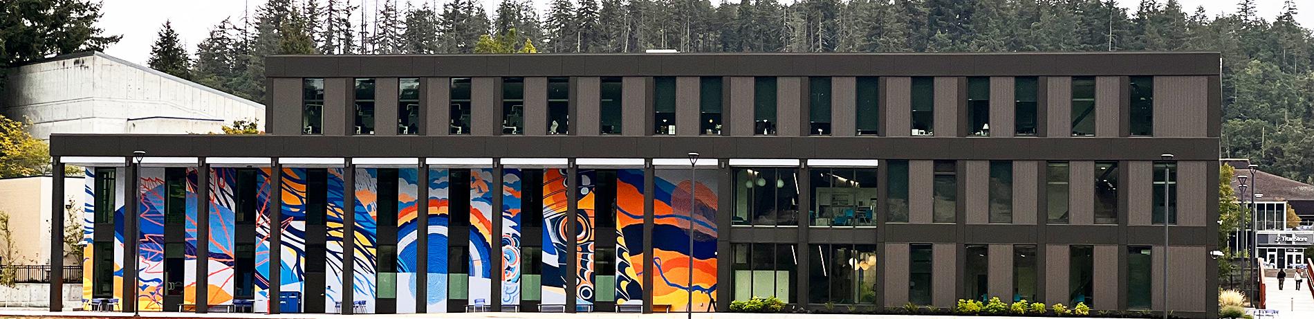 a full view of Building 32 from the soccer fields, showcasing its colorful mural