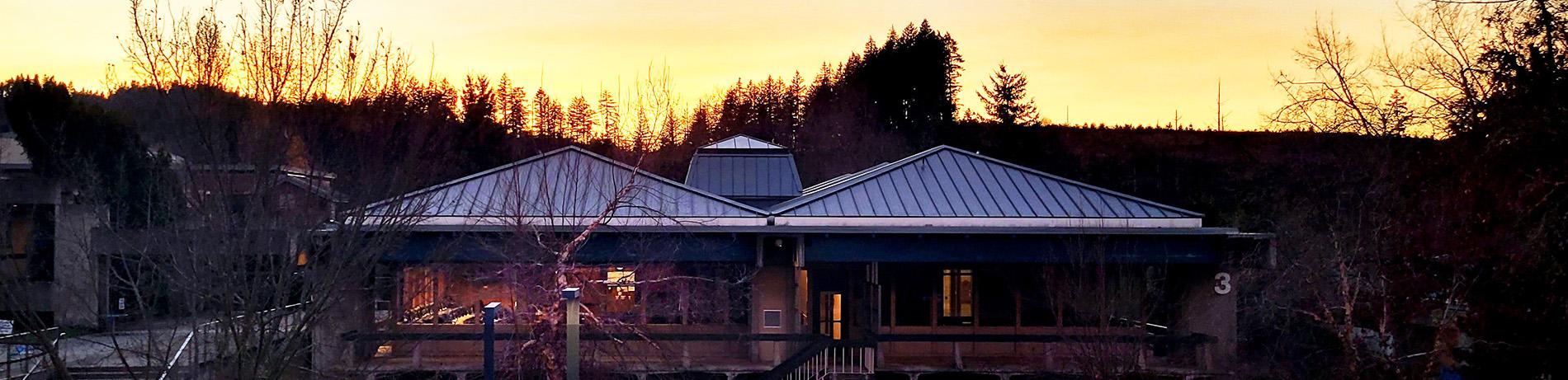 a beautiful sunset with the silhouette of the forest, with Building 3 in the foreground