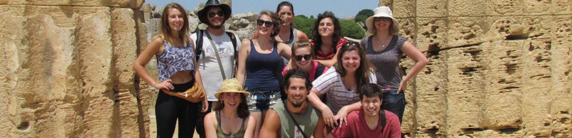International internship photo of a group outdoors near a stone monument
