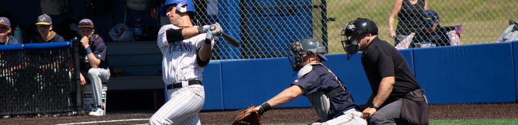 a Lane baseball player hits a ball on the new baseball field as the opposing team watches