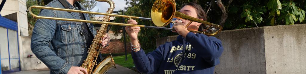 two young men, music students, playing together (a saxophone and trombone)