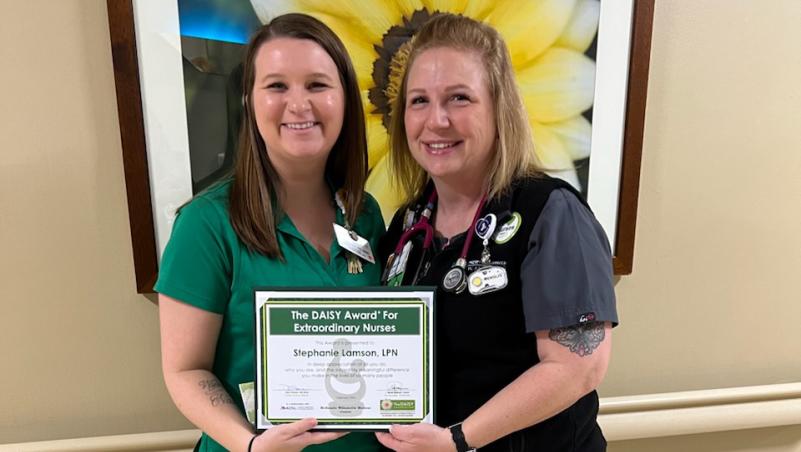 Lane Community College Student and LPN Stephanie Lamson (right) is presented the DAISY Award by McKenzie-Willamette Medical Care Unit Manager Miranda Perrigan