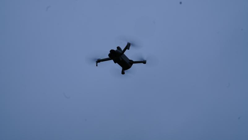 A drone is shone from underneath with the blue sky as a background.