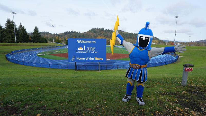 LCC Mascot Ty the Titan at track with welcome sign