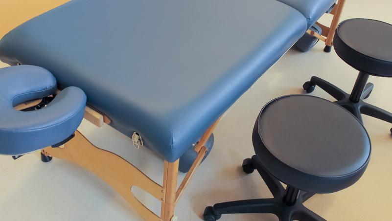 massage table and a stool at a massage school for a massage therapy program