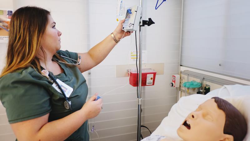Nursing student with educational mannequin