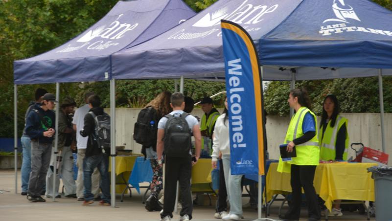 Students gather at Lane Community College welcome tents with staff assisting