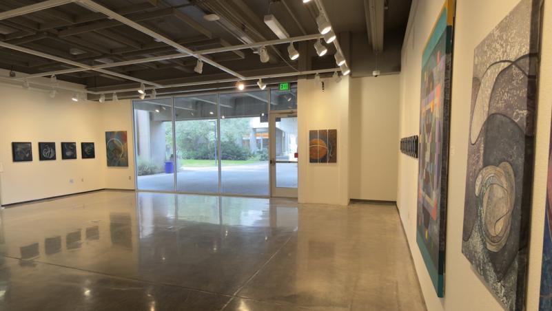 The brightly lit LCC Art gallery with abstract, 2D art on the walls