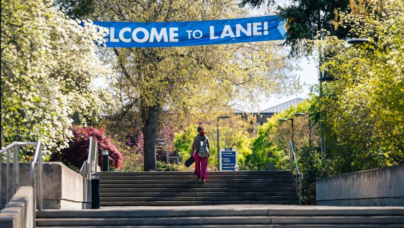 student walking up stairs with welcome side overhead