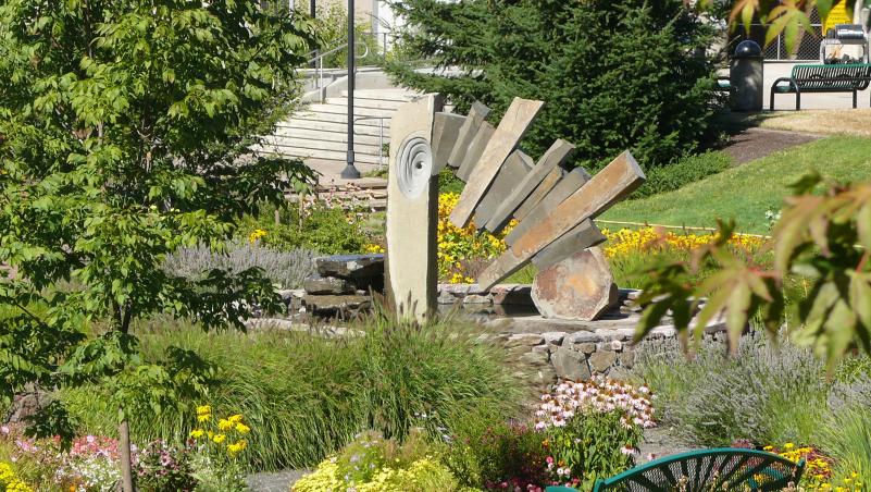 A fountain between buildings 1 and 4, with foliage around it