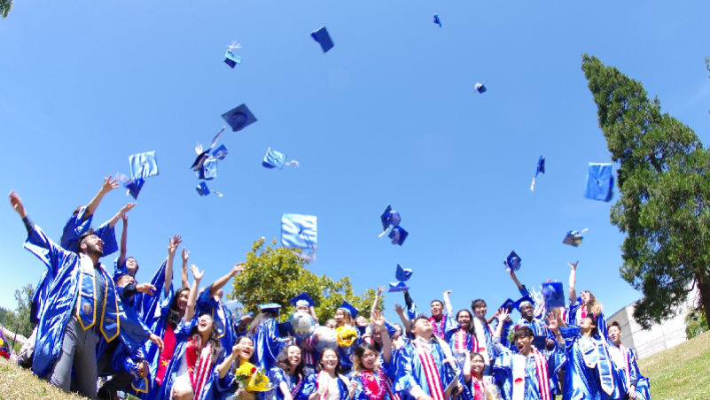 Students doing a graduation cap toss