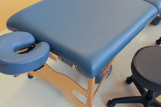 massage table and a stool at a massage school for a massage therapy program