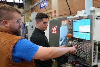 Instructor demonstrates machinery in CNC Lab at Lane Community College