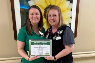 Lane Community College Student and LPN Stephanie Lamson (right) is presented the DAISY Award by McKenzie-Willamette Medical Care Unit Manager Miranda Perrigan