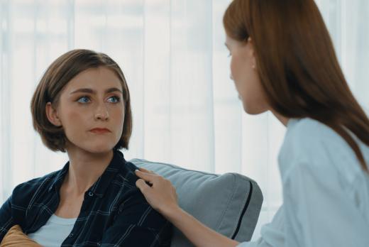 One person holding the shoulder of another as they have a discussion.  