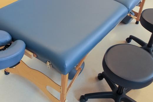 massage table and a stool at a massage school for a massage therapy program